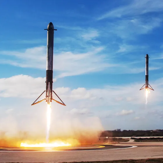 Two Falcon 9 boosters firing their engines during a synchronised landing